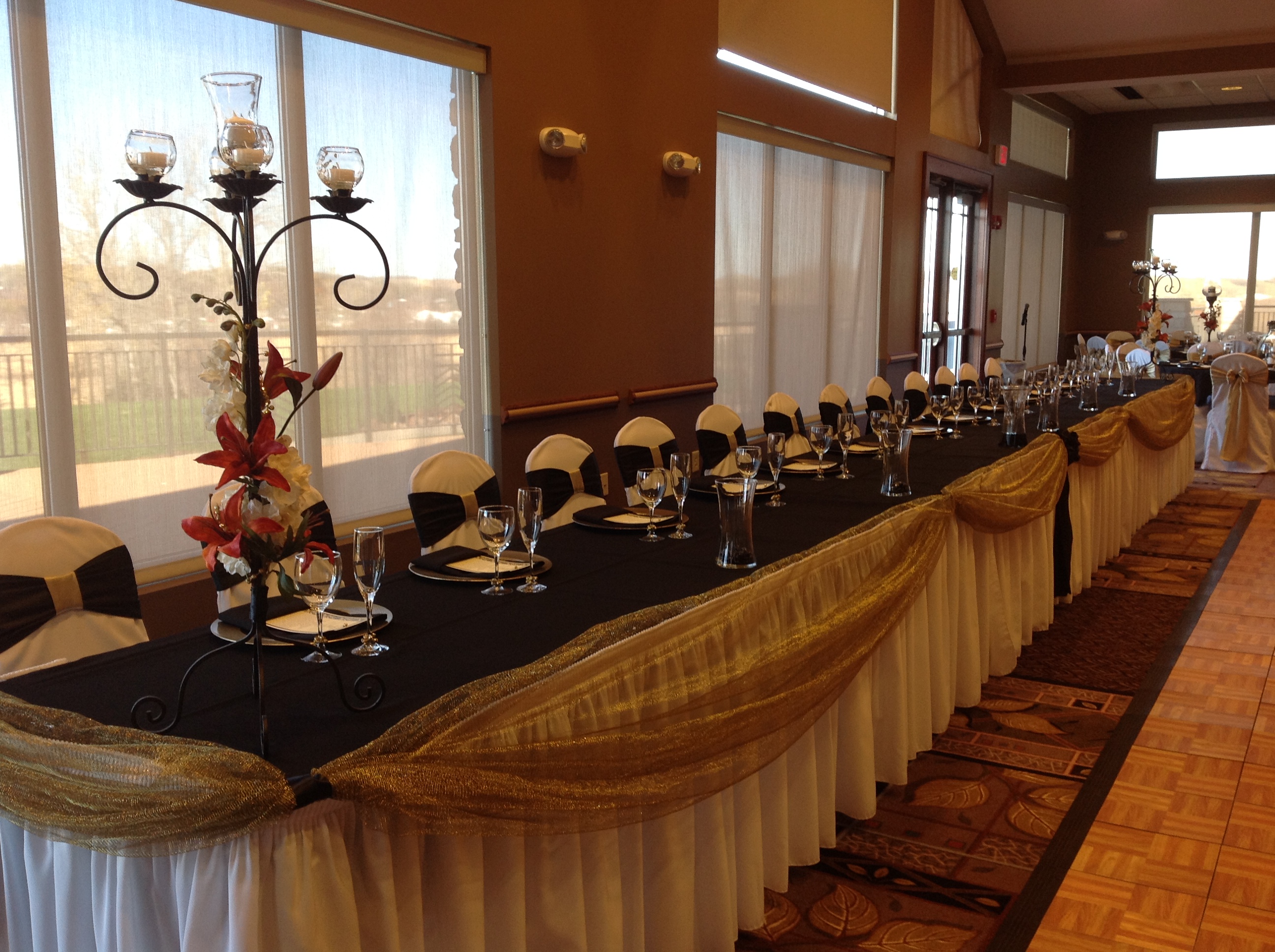 Wedding reception head table with black and gold decorations