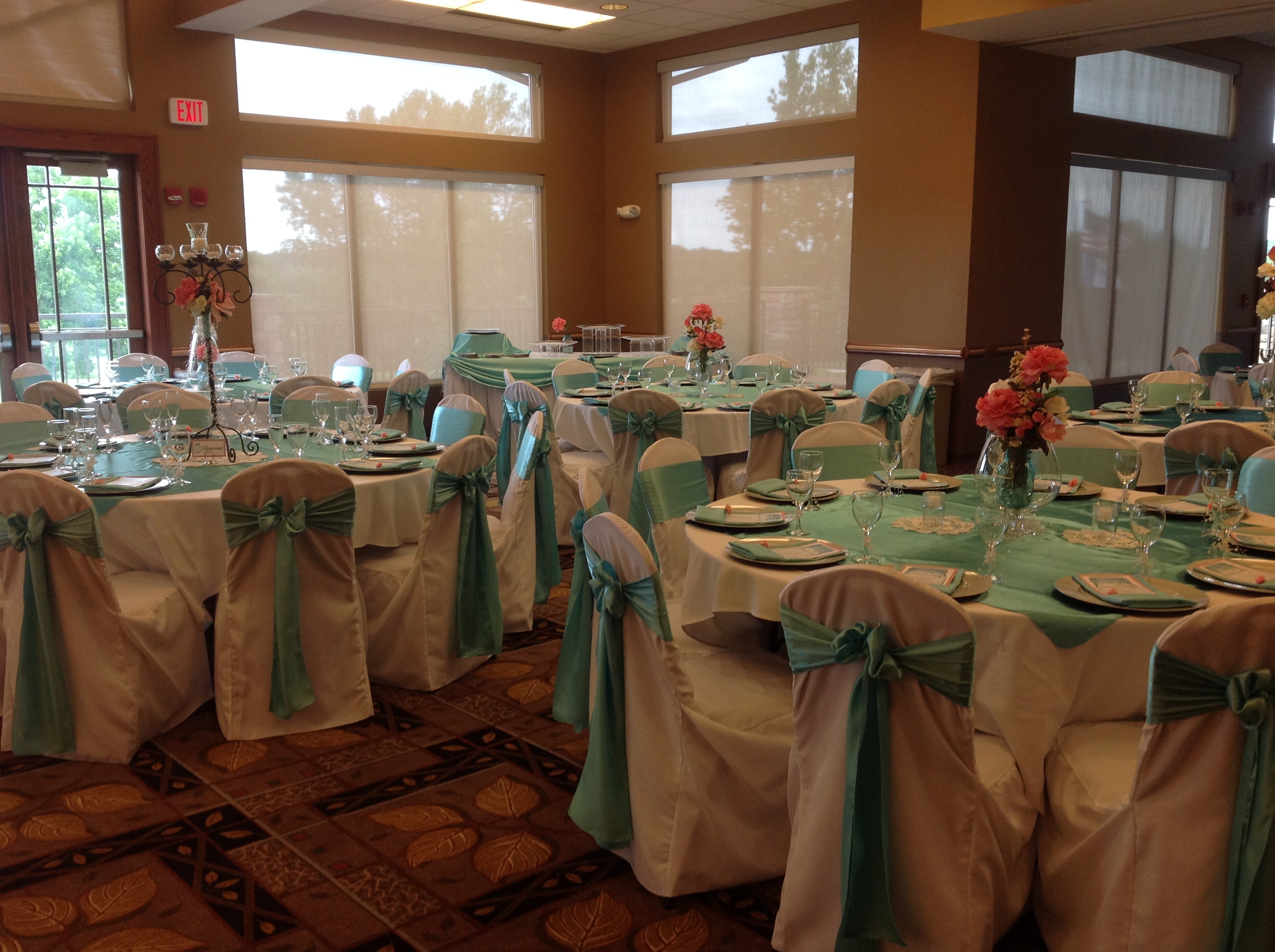 Wedding reception with teal table settings and pink flowers