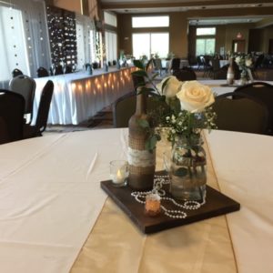 Wedding centerpiece with flowers, jar and candle