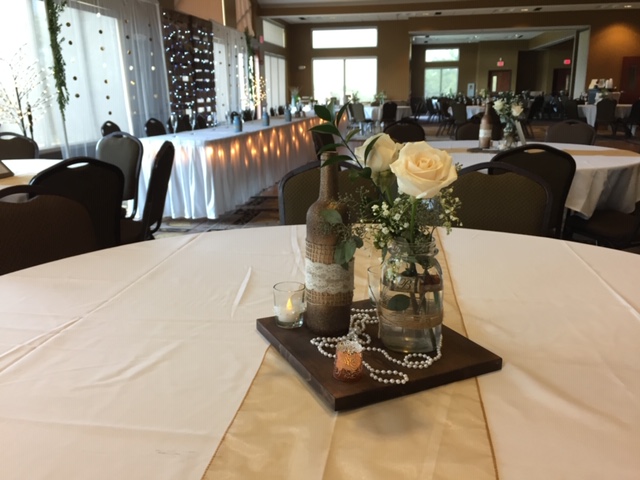 Wedding centerpiece with flowers, jar and candle